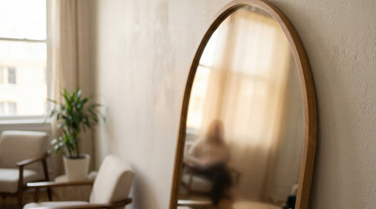 Image of mirror with blurred view of person sitting in a chair.