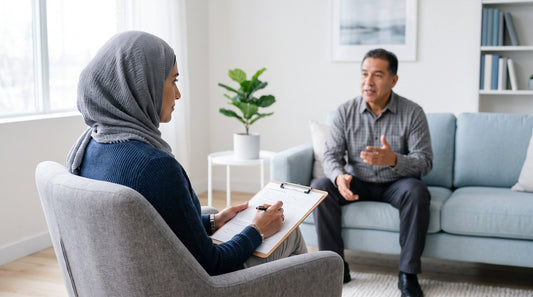 Psychologist with an intake form on a clipboard listening to a new client in a first therapy session.